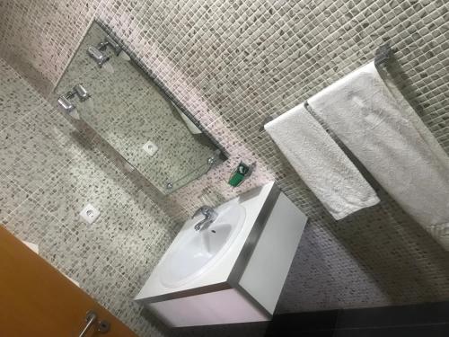 een badkamer met een wastafel en een spiegel bij Vivi Hotel in Praia