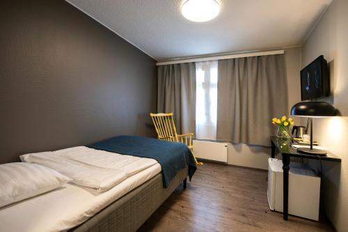 Un pat sau paturi într-o cameră la Koto Hotel Pihtipudas