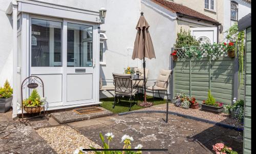 a patio with an open door and an umbrella at Cottage in Worcestershire in Evesham