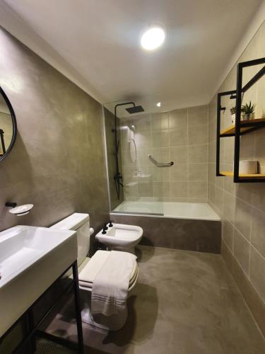a bathroom with a toilet and a sink and a tub at LOCADOR Nueva Cordoba 3C in Cordoba