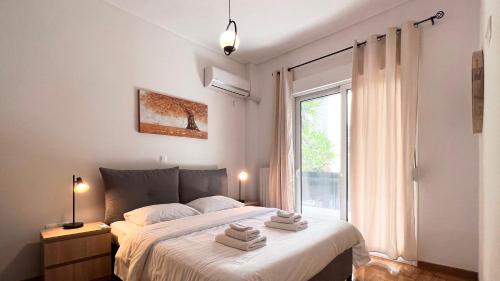 una camera da letto con un grande letto con asciugamani di Key Biscayne Elegant 77sqm apt in Paleo Faliro ad Atene