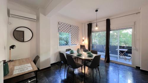 - une salle à manger avec une table, des chaises et un miroir dans l'établissement Key Biscayne Elegant 77sqm apt in Paleo Faliro, à Athènes