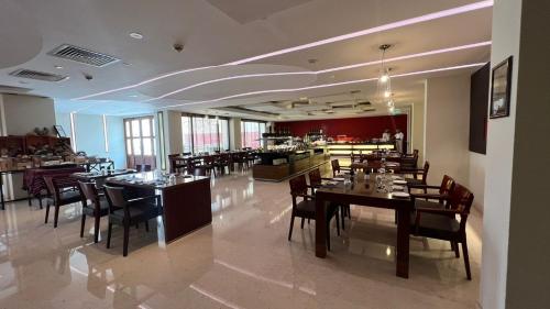 a dining room with tables and chairs in a restaurant at Crowne Plaza Sohar by IHG in Sohar