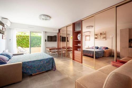 ein Hotelzimmer mit 2 Betten und einem Esszimmer in der Unterkunft SUPERBE STUDIO AVEC TERRASSE EN FRONT DE MER in Menton