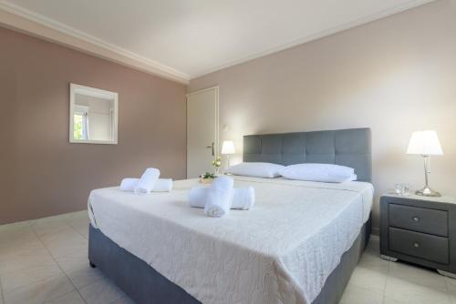 a bedroom with a large bed with white sheets and pillows at Ioanna s house.Gorgeous house with sea view in Dhílesi