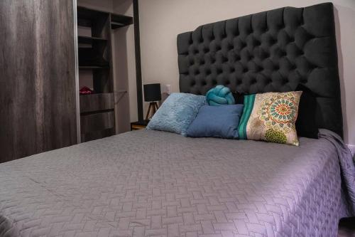 1 dormitorio con 1 cama grande y cabecero grande en Casa a una calle del Kiosko Morisco., en Ciudad de México