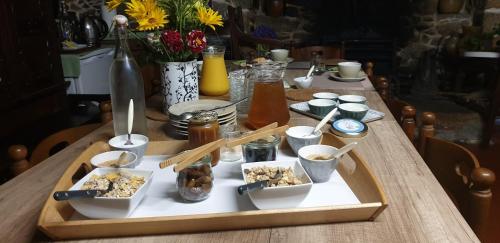 een houten tafel met een dienblad met eten erop bij La vallée du Rivoal in Lopérec