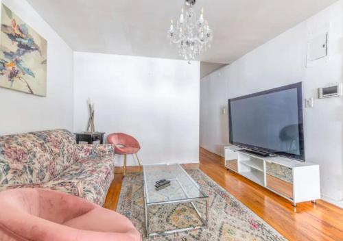 sala de estar con sofá y TV de pantalla plana en Beautiful 3BR 1BA Apartment in Kips Bay, en Nueva York