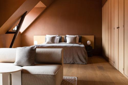 a bedroom with a bed and a couch at Audo Copenhagen in Copenhagen
