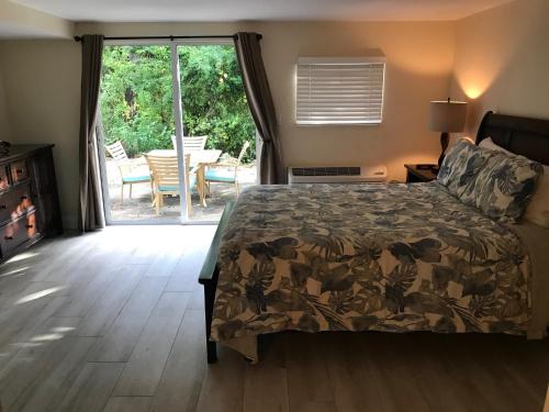 1 dormitorio con 1 cama y puerta corredera de cristal en LICENSED MGR - 3/3.5 MODERN VILLA - KEY LARGO'S PREMIER OCEANFRONT RESORT AND MARINA! en Key Largo