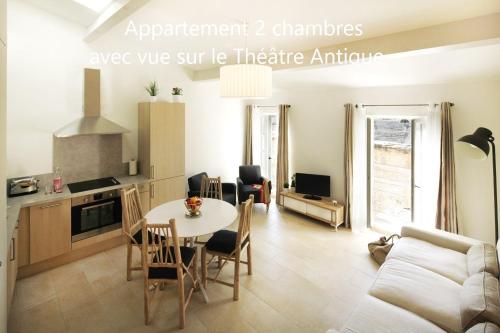 a kitchen and a living room with a table and chairs at Holiday in Arles -Appartement du Théâtre Antique in Arles