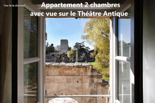 an open window with a view of the ruins at Holiday in Arles -Appartement du Théâtre Antique in Arles