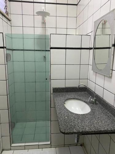 ein Badezimmer mit Waschbecken und Spiegel in der Unterkunft Hotel Central Gold-Econômico in Manaus