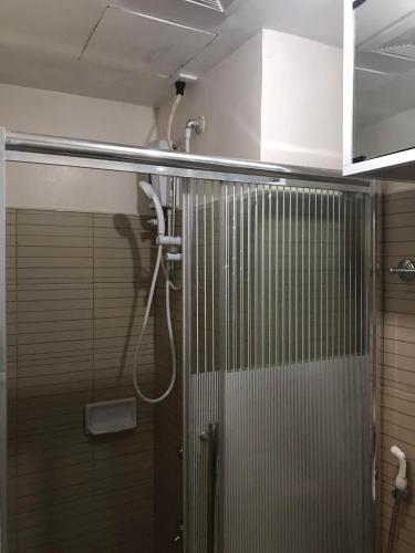 a shower with a glass door in a bathroom at Moldex Residence in Baguio