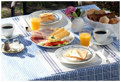 Una mesa azul y blanca con alimentos para el desayuno y jugo de naranja. en Willa Ludwinia, en Gdynia