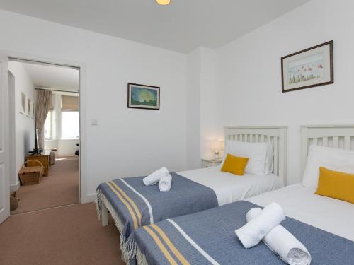 a hotel room with two beds with towels on them at Pass the Keys Spectacular Sea View Apartment with free Parking in Trearddur