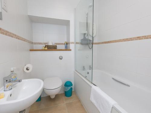 a bathroom with a sink and a toilet and a shower at Pass the Keys Spectacular Sea View Apartment with free Parking in Trearddur