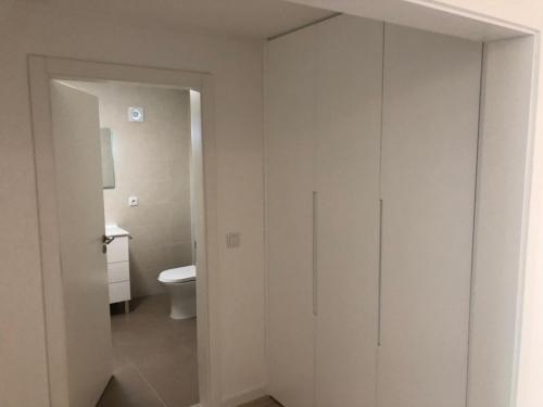 a bathroom with a toilet and a white door at House with Private Pool in Cabeceiras de Basto - 250 m² in Cabeceiras de Basto