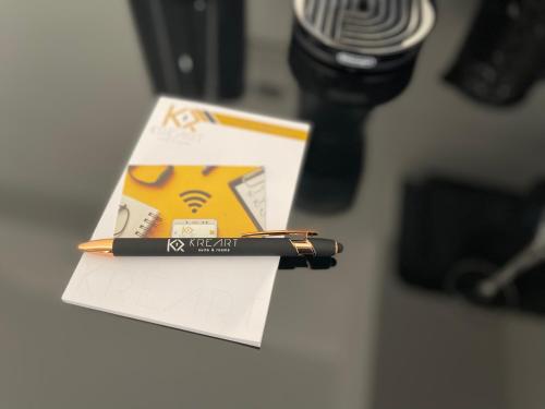 a pen on top of a piece of paper next to a microphone at Kreart Suite & Rooms B&B in Crotone