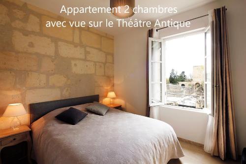 a bedroom with a bed and a window at Holiday in Arles -Appartement du Théâtre Antique in Arles