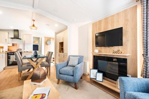 a living room with a table and chairs and a fireplace at Hedgehope Retreat in Swarland