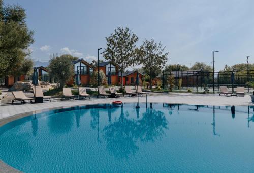 a large swimming pool with chairs in a park at Hysaj Agroturizëm in Shkodër