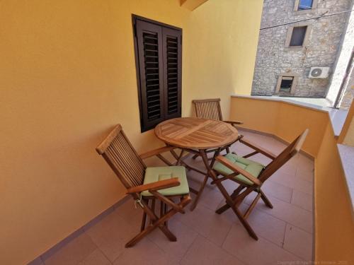a table and chairs on the balcony of a house at Guesthouse Stivan (920) in Štivan