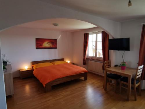 1 dormitorio con 1 cama y mesa con escritorio en Jurastei 16, en Wiedlisbach