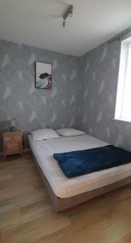 - une chambre avec un lit doté d'une couverture bleue dans l'établissement L'Opale, à Berck-sur-Mer