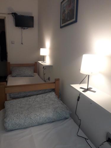 a bedroom with two beds and a lamp and a tv at Jasmin in Belgrade