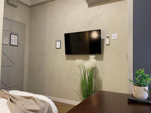 a living room with a flat screen tv on a wall at L'EMBLEME - BOUTIQUE HOTEL in Beaurepaire