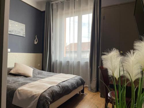 a bedroom with a bed and a large window at L'EMBLEME - BOUTIQUE HOTEL in Beaurepaire
