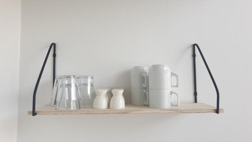 a shelf with vases and mugs on it at Cottages by the Sea in Sørvágur