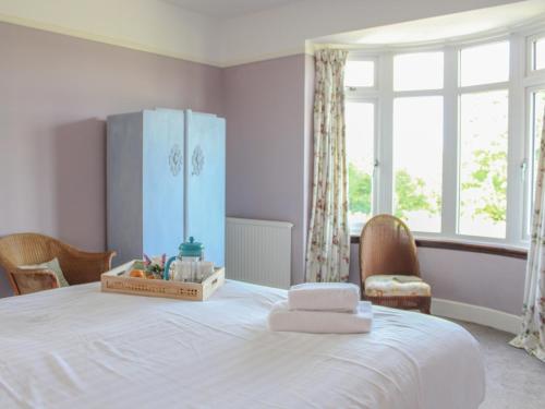 a bedroom with a white bed with a blue refrigerator at Spacious family home close to Llandeilo in Llandeilo