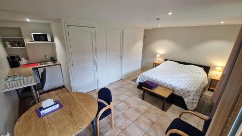 a bedroom with a bed and a table and chairs at Gîte de la Noyelle à Sainghin en Mélantois in Sainghin-en-Mélantois