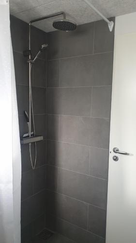 a bathroom with a shower with a shower head at Cottages by the Sea in Sørvágur