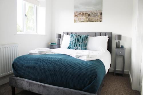 a bedroom with a bed with a blue comforter at Oxford - Private House with Garden & Parking 14 in Yarnton