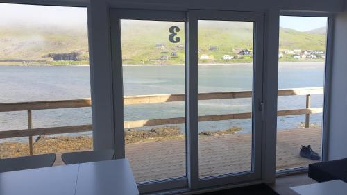 a view of the ocean from a room with sliding glass doors at Cottages by the Sea in Sørvágur