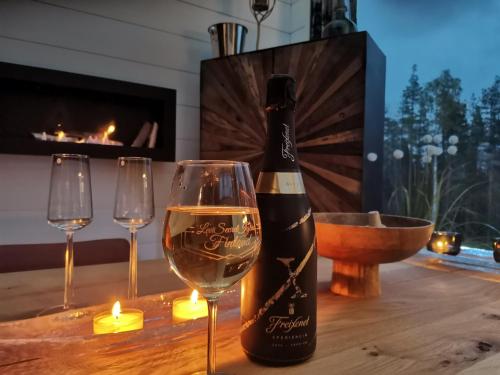 a bottle of wine on a table with two glasses at Levi Secret Igloo Revontuli in Levi