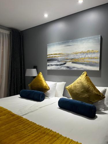 a bedroom with a white bed with yellow pillows at Luxury Apartment - Michelangelo Towers in Johannesburg