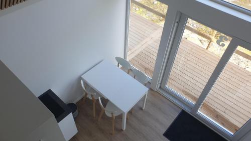 a white table and chairs in a room with a balcony at Cottages by the Sea in Sørvágur