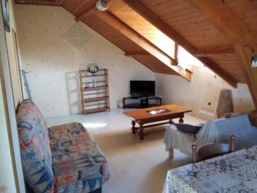 a living room with a couch and a table at appartement calme en pleine campagne in Malaussanne