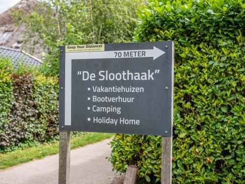 a sign that is in front of a hedge at De Sloothaak in Giethoorn