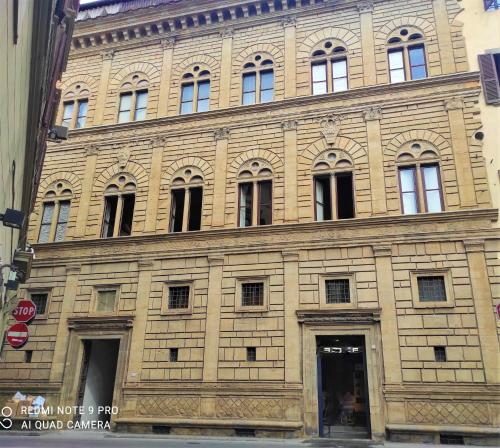 duży ceglany budynek z oknami wychodzącymi na ulicę miejską w obiekcie ATTICO RUCELLAI CON TERRAZZA SUPER VISTA we Florencji