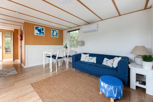 sala de estar con sofá azul y cocina en 87, gelegen in het rustige & bosrijke Oisterwijk!, en Oisterwijk