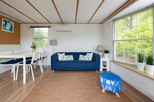 un soggiorno con divano blu e tavolo di 87, gelegen in het rustige & bosrijke Oisterwijk! a Oisterwijk