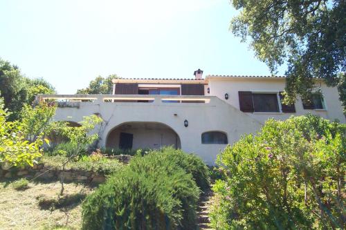 a white house with a lot of trees and bushes at Domise in Conca