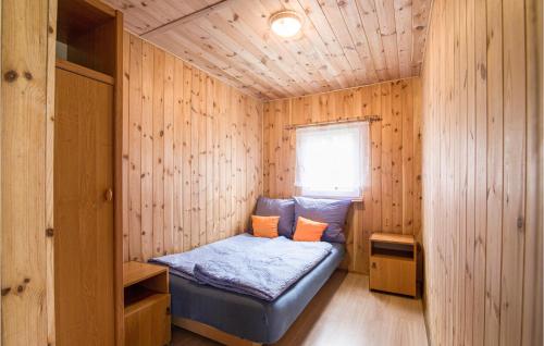 a small room with a bed in a wooden cabin at Gorgeous Home In Jedwabno With Kitchen in Jedwabno