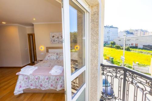 een slaapkamer met een bed en een balkon met uitzicht bij APARTAMENTOS RIAMAR 2 in Ribadeo