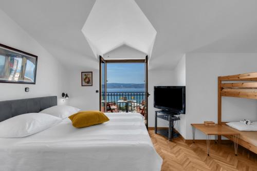 a bedroom with a bed and a television and a balcony at Room 79-7 in Duće